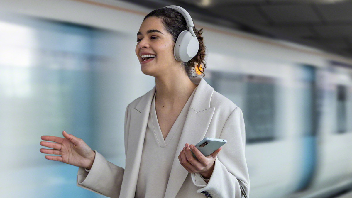 Naine kandmas Sony XM5 kõrvaklappe raudteejaamas