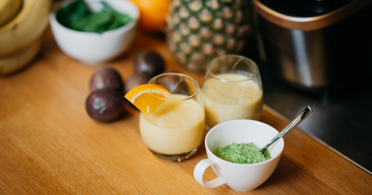 Vitamiinirikas roheline ja kollane smuuti laua peal