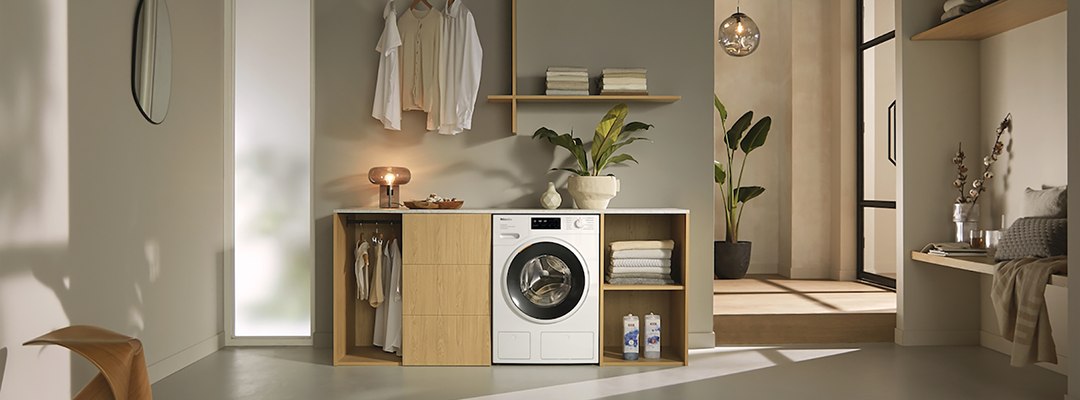Стиральная машина Miele с фронтальной загрузкой в стильной и светлой домашней прачечной