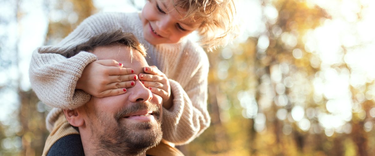 Радостный ребёнок на плечах у отца