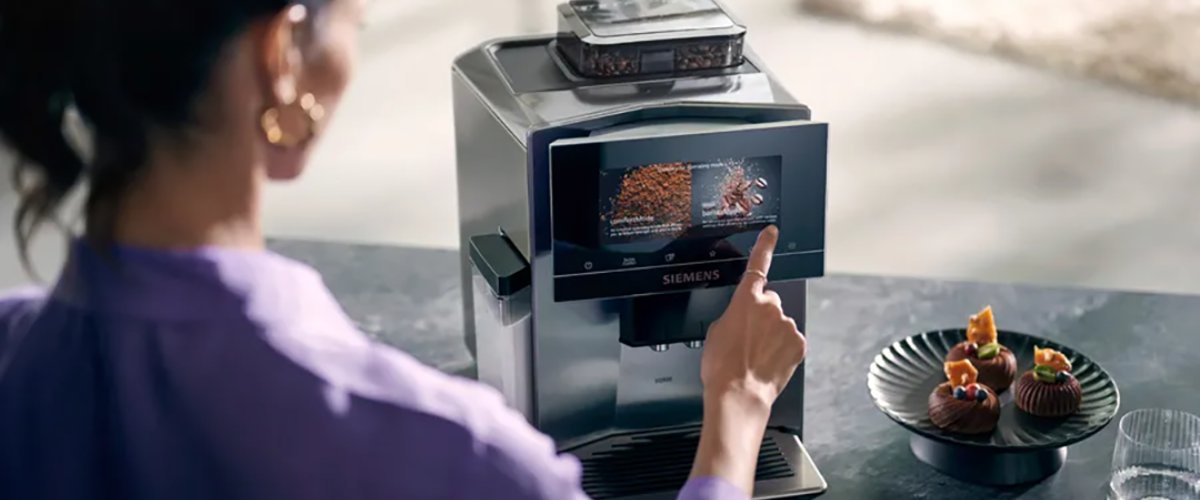Naine puudutamas Siemens EQ900 täisautomaatse kohvimasina puutetundlikku ekraani