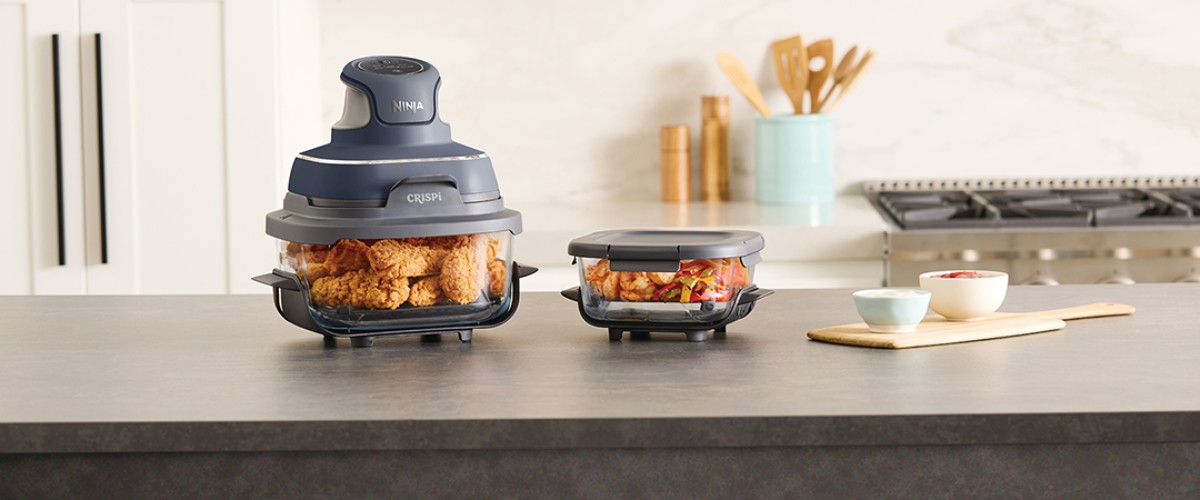 Ninja Crispi kaasaskantav kuumaõhufritüür koos valmistoiduga köögitasapinnal