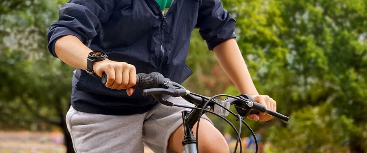 Laps jalgrattaga õues, randmel Garmin Bounce 2 nutikell
