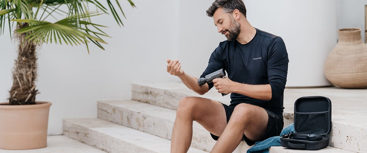 Мужчина держит в руках массажер Beurer и расслабляет мышцы