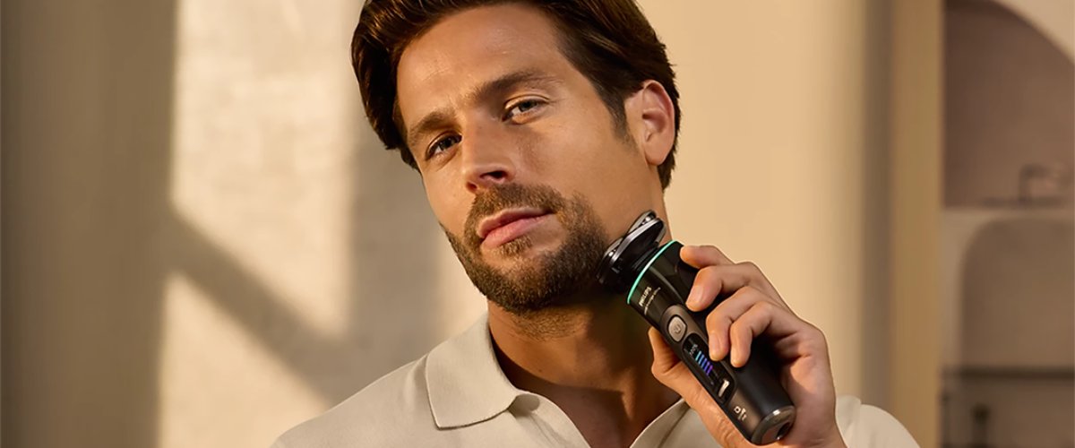 Mees hoiab käes Philips i9000 Prestige Ultra pardlit ja ajab habet