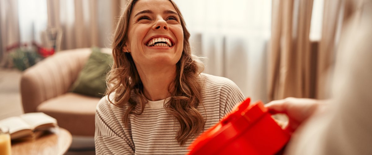 naeratav naine võtmas vastu sõbrapäeva kingitust