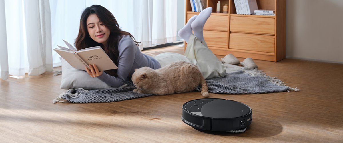 Robottolmuimeja puhastamas põrandat naise ja lemmiklooma kõrval