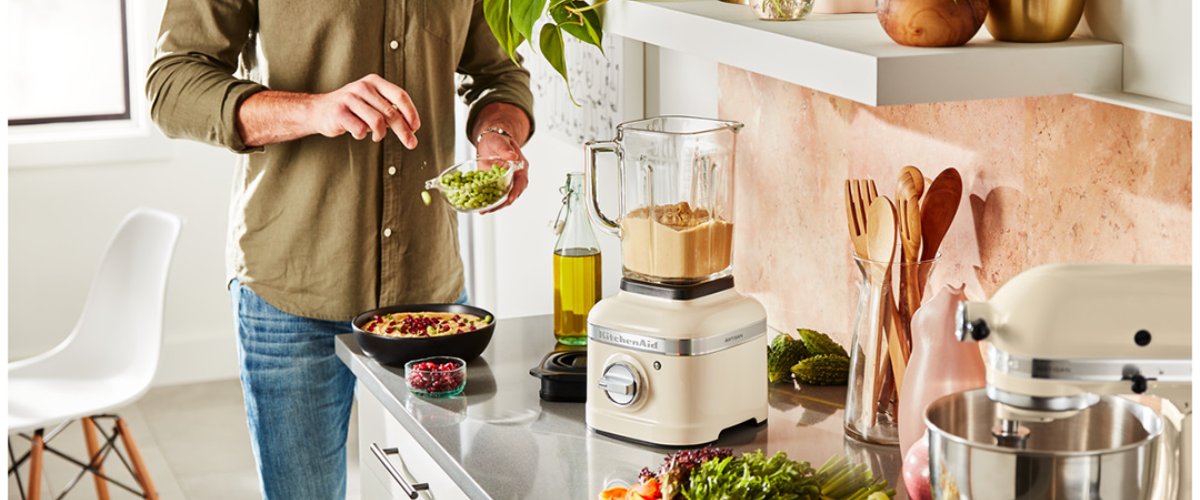 Мужчина готовит на кухне полезную еду с помощью блендера KitchenAid Artisan K400 со стеклянным кувшином